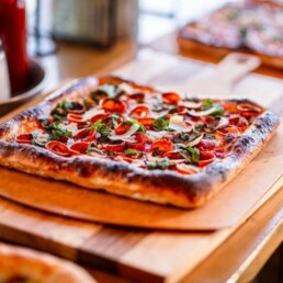 close up of gourmet pizza on table at restaurant